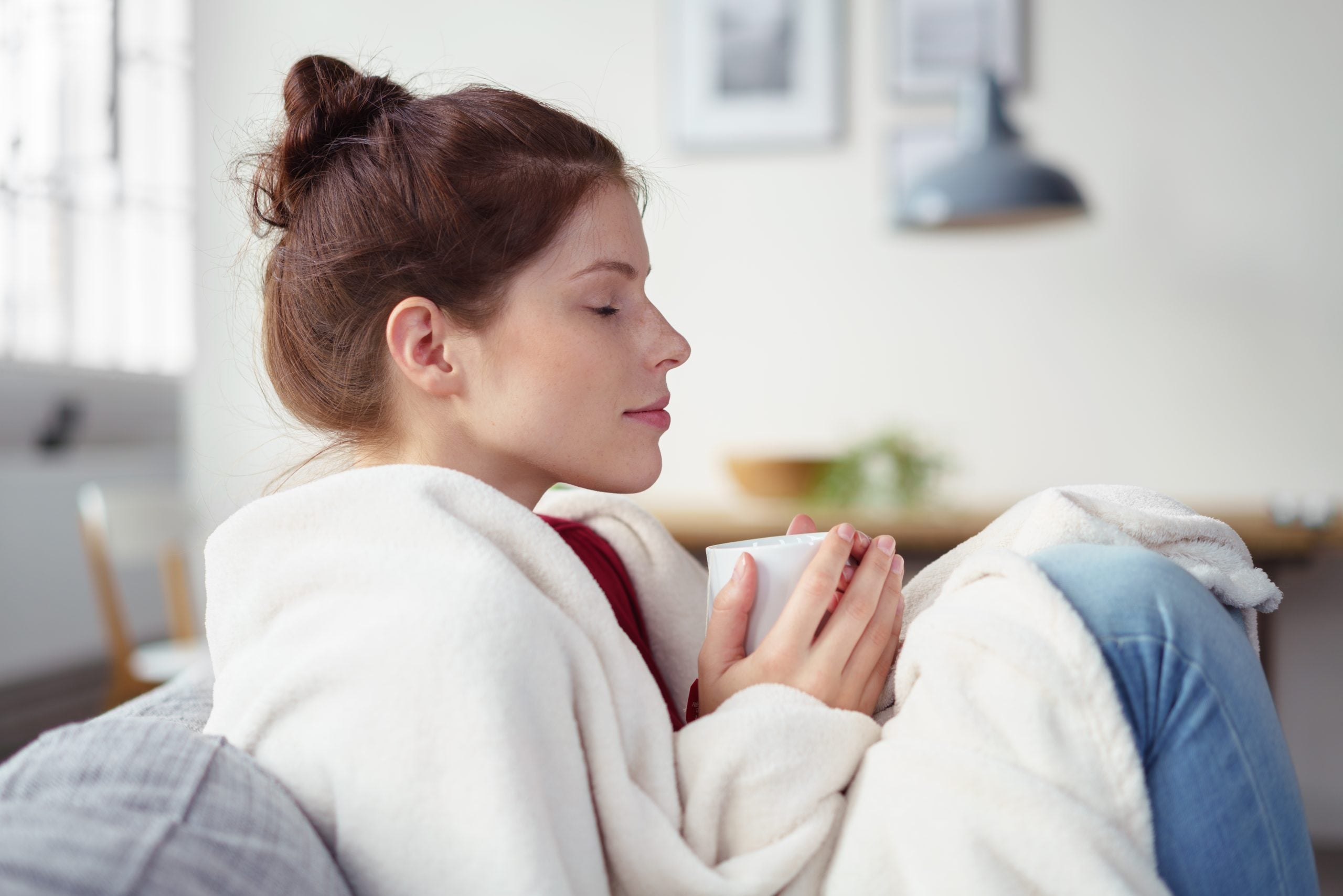 Woman,Holding,A,Cup,Of,Warm,Tea,While,Relaxing,On